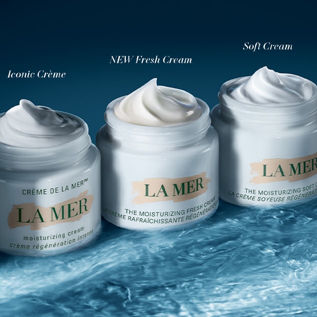 Line up of three La Mer moisturisers sitting on water.
